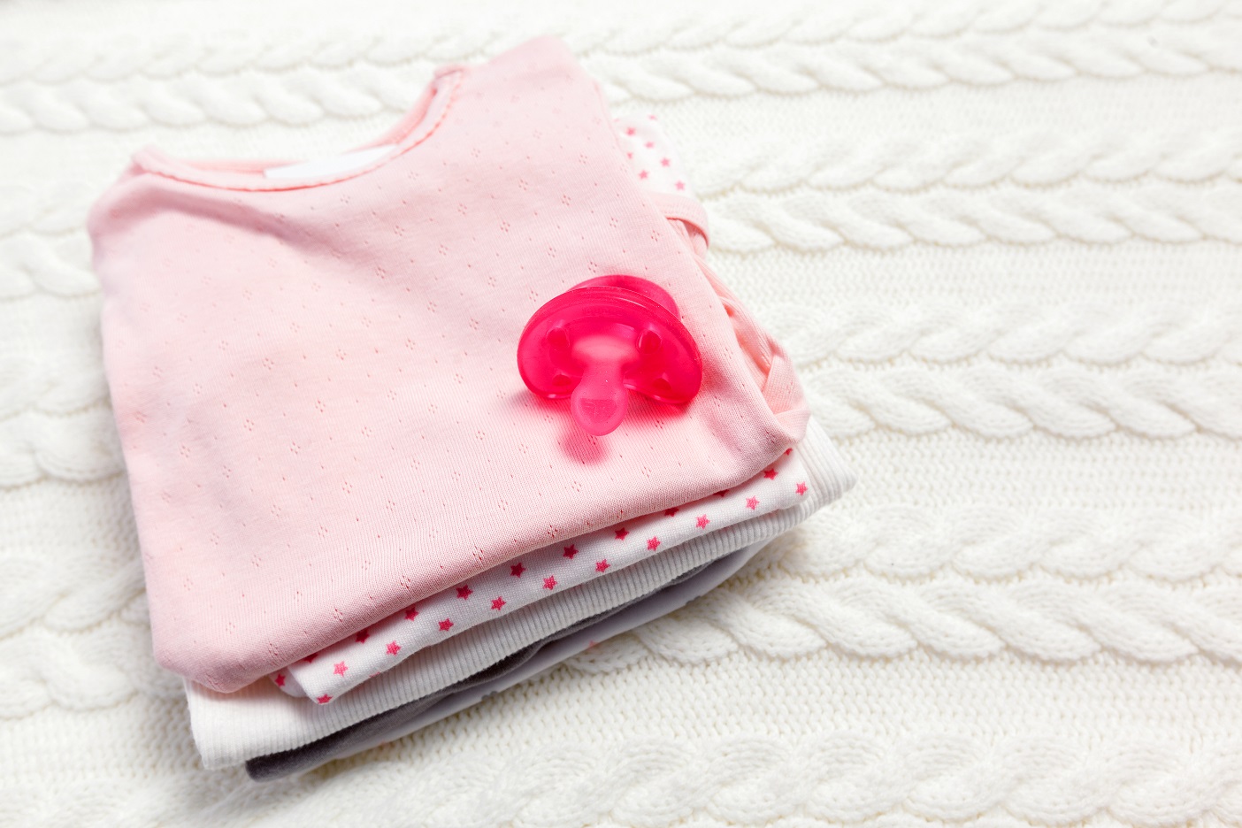 close up of baby clothes for newborn on table